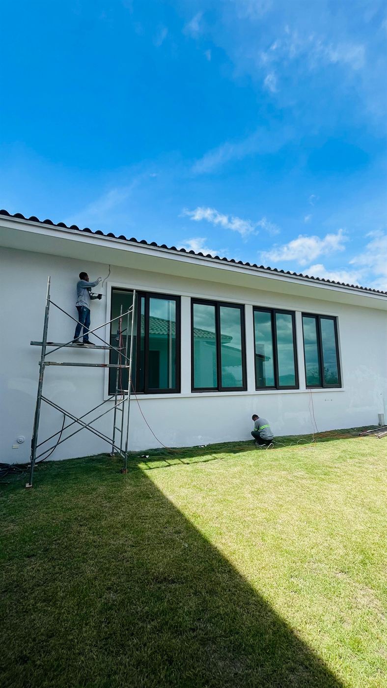Fachada con ventanería de vidrio en obra residencial